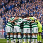 Can you give me an image of a Celtic-style huddle at an Ibrox adjacent stadium where there are only home supporters, all in b