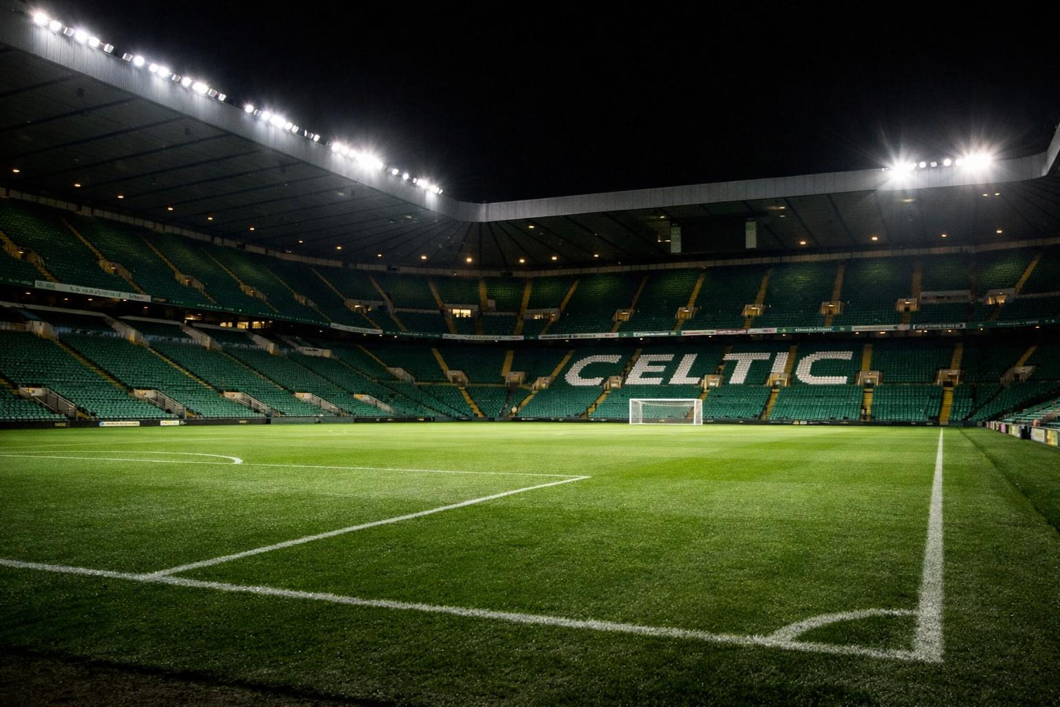Can I have an image of a Celtic-like stadium, with all its green seats empty and the floodlights illuminating the pitch?
