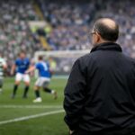 View from behind of a martin o'neill look-alike standing on the touchline watching the game between us and the team from ibro